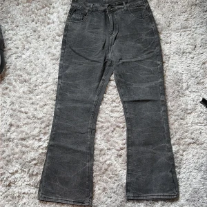 Grå bootcut jeans med vintage vibe - Snygga grå jeans med bootcut passform och klassiska fem fickor. Jeansen har en cool tvättad look och raka ben som slutar i en lätt utsvängning. Perfekta för dig som gillar en avslappnad men trendig stil.