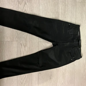 Replay Hyperflex Anbass svarta jeans - Svarta Replay Hyperflex Anbass jeans med slim passform. MÅTT: längd insida: 68cm. Längd  utsida: 92cm. Midja: 76cm. Midja till framsida gren: 27 cm.  Skriv om du undrar något