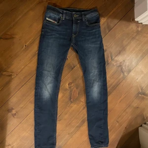 Mörkblå skinny jeans från Diesel - Snygga mörkblå jeans från Diesel i skinny fit med klassiska fem fickor och slitningar på låren. Perfekt för dig som vill ha ett par feta byxor billigt.