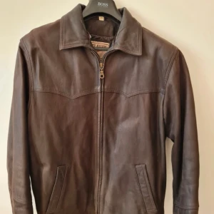 Jacka i äkta skinn, storlek 50, Herr, Sky Hawk - Läder jacka har köpts i Grekland, helfodrad. Jackan har två stycken inne fickor, en av de med dragkedja. Kan hämtas i Vallentuna.