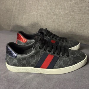 Gucci sneakers - Snygga Gucci sneakers i svart med klassiskt GG-mönster.                                                                        Smått använda därav de ”billiga” priset.                      Perfekta för dig som vill sticka ut med lyxig streetstyle.                                                                                 Priset är ej hugget i sten!