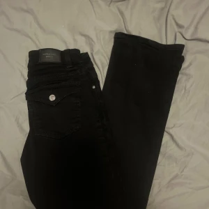 Svarta jeans från Gina Tricot - Snygga svarta jeans från Gina Tricot med klassisk femficksdesign och silverfärgade knappar. Modellen har en enkel och stilren look som passar till det mesta. Perfekta för dig som gillar en clean och tidlös stil. Helt oanvända. 