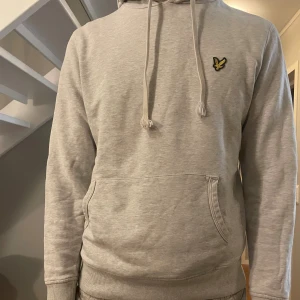 Lyle and scott hoodie - M - Riktigt fin Lyle and scott hoodie i ljusgrått. Riktigt snygg ljusgrå färg som passar till alla sorters färger. Köpt på NK för cirka 4 månader sedan men tyvärr för liten nu, den har inte krympt eller så jag har bara växt ifrån den. Perfekt skick inga hål eller skador och kostar cirka 899 ny. Nytt skick. Storlek M