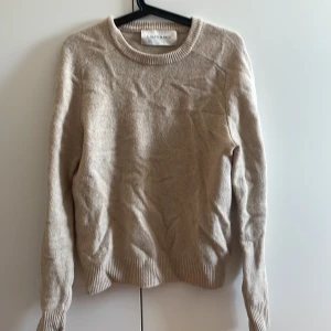 Beige stickad tröja från A Day's March - Snygg beige stickad tröja från A Day's March i storlek small. Tröjan har rund hals, ribbade muddar och långärmad design. Perfekt för dig som gillar stilrena och klassiska plagg med mjuk känsla. Har ett pyttelitet hål på framsidan. Kan skicka bild!