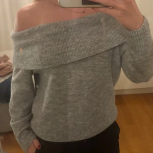 Grå offshoulder stickad tröja  - Superfin grå stickad tröja från H&M i offshoulder-modell. Tröjan har bred ribbad kant upptill som ger en snygg och avslappnad look. Är i storlek XS men skulle säga att den passar S bättre.