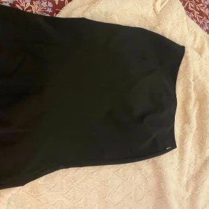 Svart kjol från Moschino Jeans - Snygg svart kjol från Moschino Jeans med klassisk rak passform. Kjolen är enkel och stilren, perfekt för dig som gillar minimalistisk stil. Tillverkad i ett mjukt material som känns bekvämt hela dagen.