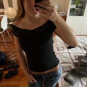 Svart off shoulder topp - Säljer en skit snygg svart off shoulder topp med spets ifrån Nelly. Helt oanvänd och säljer pga att den är för liten. Nypris 249kr.