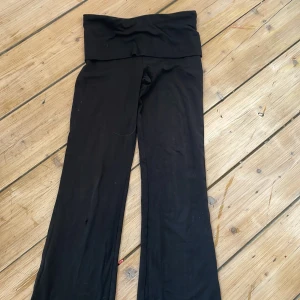 Svarta yoga pants med hög midja - Svarta yoga pants med bred, hög midja och utsvängda ben. Mjukt och stretchigt material som är riktigt skönt att ha på sig. Perfekta för chill eller träning. Snygg och enkel design utan synliga detaljer.