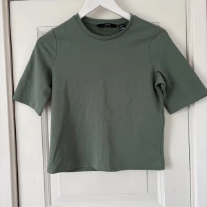 Grön basic t-shirt från vero Moda  - Enkel och stilren grön t-shirt från vero Moda med rund hals och korta ärmar. Modellen är rak, perfekt till jeans eller kjol. Tillverkad i mjuk bomull som känns skön mot huden.