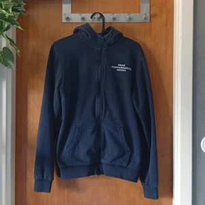 Peak Performance kofta - Mörkblå Peak Performance kofta Stilren kofta med dragkedja och huva, utrustad med två fickor framtill och en diskret logga på bröstet. Bekväm passform och hög kvalitet – perfekt för både vardag och träning ✨ I fint skick. Hör gärna av dig vid intresse eller frågor 💬 