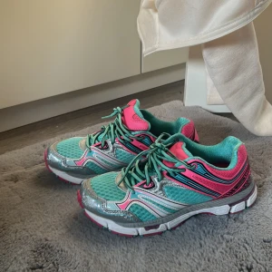 Turkosa och rosa sneakers strl 37 - Snygga sneakers i turkos mesh med detaljer i silver och rosa. Skorna har snörning, vit och rosa sula samt coola kontrastdetaljer.