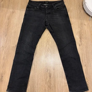 Svarta raka jeansbyxor - Svarta jeansbyxor från jack&jones med klassisk femficksdesign och raka ben. Jeansen har normal midja och är tillverkade i ett mjukt bomullsmaterial med lite stretch för extra komfort. Perfekta för en clean och stilren look.