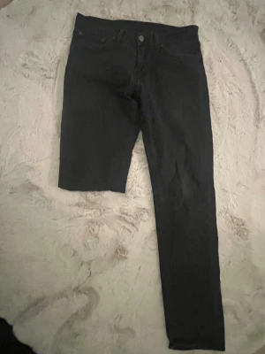 Svarta Levi's 511 jeans W29 L32 - Säljer ett par svarta Levi's 511 jeans med klassisk femficksdesign och snyggt läderpatch bak. Modellen är slim fit med rak siluett och normal midja. Jeansen är tillverkade i mjukt och slitstarkt denim som sitter skönt hela dagen.