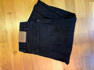 Svarta wide jeans från sweet sktbs - Säljer ett par svarta jeans från sweet sktbs i modellen Sweet Big Skate. De har bred passform, raka ben och är tillverkade i 100% bomull. Klassisk femficksdesign med logga på bakfickan och metallknappar. Perfekt för dig som gillar streetwear.