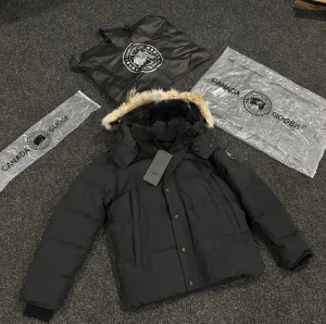 Svart dunjacka från Canada Goose - Säljer en svart dunjacka från Canada Goose med avtagbar huva och snygg pälsdetalj. Jackan har klassisk patch på ärmen, dragkedja och knappar framtill samt flera praktiska fickor. Perfekt för kalla dagar och riktigt stilren look. Priset kan diskuteras vid snabb affär, skickas samma dag💨💨