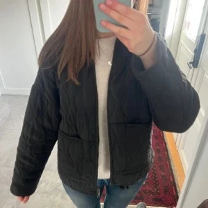 Svart quiltad jacka  - Quiltad svart jacka från Zara, dragkedja framtill och fickor. Jackan har snörning i nederkant för att justera passformen. Storlek S