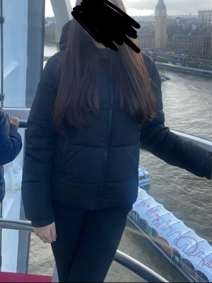 Svart pufferjacka med luva - Säljer en svart pufferjacka med luva och dragkedja framtill. Jackan har en clean look och är perfekt för kalla dagar. Den är quiltad och har en normal passform som gör den enkel att styla med olika outfits. Grym för dig som gillar streetwear-vibe. Inte använd ofta och köpt för 500kr