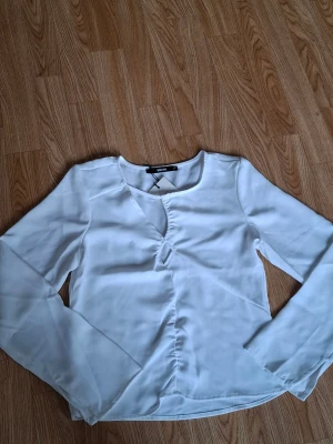 Vit blus med twistdetalj från BikBok, storlek xs  -  Helt ny!! Säljer en oanvänt långärmad blus från BikBok i storlek XS. 