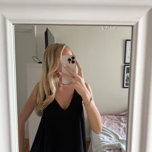 Svart linnetopp från Y.A.S - Säljer en svart linnetopp från Y.A.S med v-ringad hals och lös passform. Toppen är ärmlös och har en snygg detalj med spets baktill.