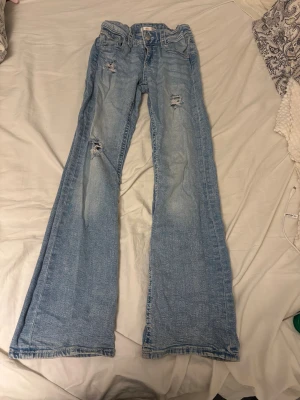 Bootcut ljusa jeans från Gina Tricot - Jag har gjort slitningarna själv. Det står att dom är i storlek 158. Måtten finns på de sista bilderna men de är 30 cm rakt över med en ställbar midja så du kan ändra midjemåttet själv och innerbenslängden är 73 cm. 