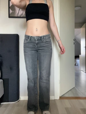 Grå bootcut jeans från Perfect Jeans - Säljer ett par grå jeans från Perfect Jeans i storlek 36. Modellen har låg midja, bootcut-ben och klassiska fem fickor. Snygga kontrastsömmar och mjukt denimtyg som sitter skönt. Perfekt för dig som gillar retrovibe och avslappnad stil.