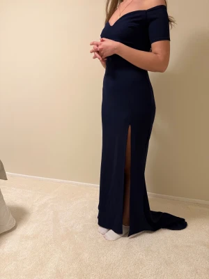 Marinblå långklänning med slits - Supersnygg marinblå långklänning med offshoulder, har använts en gång bara.