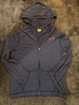 hollister zipper hoodie - Snygg hollister zipper hoodie. Den är tunn som är perfekt om man har en tjock jacka.  Den är i väldigt bra skicke Den är i size S och passar ca 168 cm. Priset kan diskuteras. Skickar snabbt!