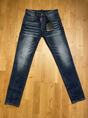 Mörkblåa designer jeans - Säljer ett par helt nya mörkblå designerjeans i passformen slim fit ny med prislapp. Jeanslängd: 101.5cm, innerbenslängd: 24,5cm, midjevidd: 72cm.  Jeans storlek W28 ”inte svensk storlek”, passar barn/ungdom 10-13 år. Passar längd cirka 150-158 cm. Skriv vid frågor.