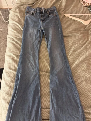 Blå bootcut jeans med hög midja - Säljer ett par Jenas i storlek S från Lager 157. Dom är utsvängda med hög midja.