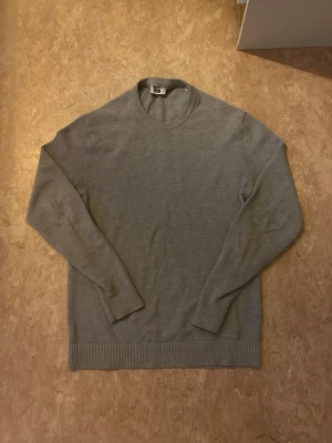 Grå stickad tröja - Säljer en enkel och stilren grå stickad tröja från WE fashion i storlek XS men den är stor i storlek och passar mer som S skulle jag säga. Tröjan har rund halsringning, ribbade muddar och lång ärm. Perfekt basplagg till garderoben och funkar året runt. 100% bomull
