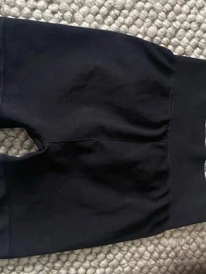 Svarta cykelshorts från HM sport stl XS helt ny  - Säljer ett par svarta cykelshorts med bred resår i midjan. De är tillverkade i mjuk bomull och har en tight passform som sitter skönt på kroppen. Perfekta till sommaren och träning eller bara att chilla i.