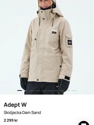 Beige skidjacka från Dope, M - Snygg beige skidjacka från Dope med huva, flera praktiska fickor. Perfekt för vinterns äventyr i backen. Är i fint skick förutom några ”revor” där nere på jackan (se bild). 