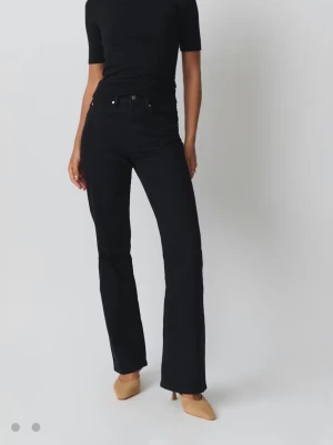 Svarta bootcut jeansbyxor - Säljer ett par svarta jeansbyxor med bootcut passform och medelhög midja. Klassisk femficksmodell. Har kortat ner byxorna så passar dig som är 155cm och kortare!