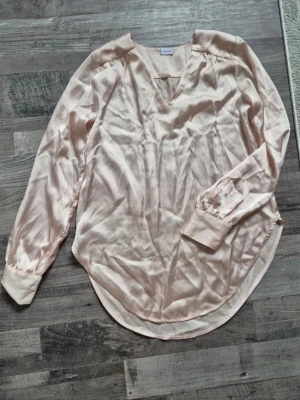 Rosa satinblus - Rosa satin blus. Lång i passformen. Använd några gånger. Inga defekter. 