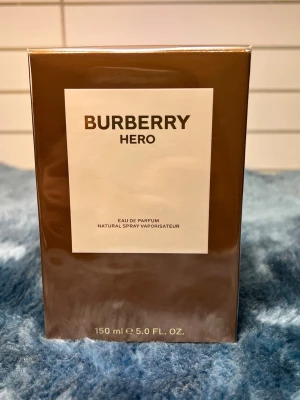 Burberry Hero EdP 150ml - Burberry Hero Eau de Parfum, 150 ml. Ingredienser: Alcohol Denat., Parfum/Fragrance, Aqua/Water, Limonene, Coumarin, Alpha-Isomethyl Ionone, Citronellol, Linalool, Eugenol, Citral, Benzyl Benzoate, Geraniol, Evernia Prunastri (Oakmoss) Extract, Cinnamal. Tillverkad i Spanien.