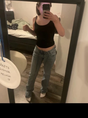  ljusblå bootcut jeans - Säljer ett par klassiska lager 157 jeans i ljusblå tvätt med bootcut passform. Jeansen har låg midja, raka ben med lätt utsvängning och tydliga sömmar längs benen. Tillverkade i slitstarkt jeanstyg med dubbla knappar i gylfen. Perfekta för en avslappnad och trendig look.( bilderna är tagen från min Vinted för att jag inte orkade ta på mig alla kläder igen) skriv vid frågor 
