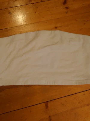 Vit tubtopp - Säljer en enkel och stilren vit  tubtopp. Materialet känns mjukt och lätt, troligen bomull eller en bomullsblandning.