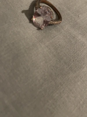 Ring - En promise ring från Pandora storlek vet jag ej men känns som en M. Ljus lila som är silverfärgad med små diamanter runt.