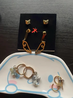 Guldörhängen i olika format - Vingarna- lite smårepor men som knappts syns - 50kr.  Glitter Guldringar i äkta platterat guld 60kr (dock ena ploppen som försvunnit ersätter med en kopparplopp) UO Fjärilsörhängen, inte bästa kvale och på ena örhänget är ögglan lite sne vilket gör så fjärilen sitter lite sne(kan fixas med tång själv) 30kr.     Edblad Allergifria Fjärilsörhängen i Kids Size (funkar för vuxna också bara mindre i strl) 80kr. Frågor? Kom Dm eller köp billigare i paketpris!                                 