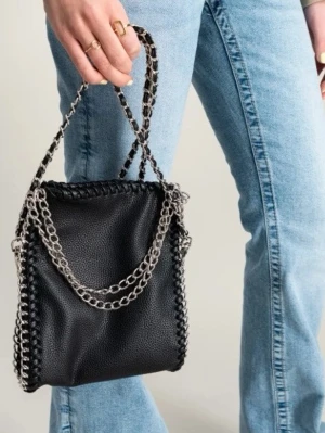 Svart glittrig axelväska med kedjedetaljer - Säljer en svart axelväska med snygga silverfärgade kedjor som axelrem och runt kanterna. Väskan har en mjuk, glansig yta och en fyrkantig form. Har knappast kommit användning