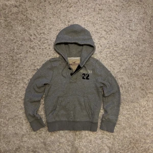 Grå hoodie från Hollister - Snygg hoodie från Hollister. Den är använd men i bra skick utan defekter. Storlek S, tveka inte på o skriva vid fler frågor!