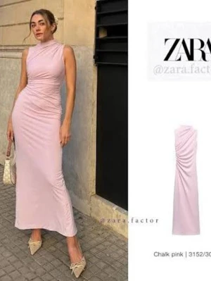 Ljusrosa långklänning från Zara - Supersnygg ljusrosa långklänning från Zara med hög hals och ärmlös design. Klänningen har en figurnära passform och fina draperade detaljer längs sidan som ger en elegant siluett. Perfekt för dig som vill sticka ut med en stilren look.