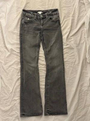 Gina tricot Jeans - Ljusgrå jeans från Gina tricot young 9 - 14 (storlek 158) med snygg design på bakfickorna. Det är lite slitage längst ner på benen, men annars är de i bra skick! Det finns resorband i midjan :)