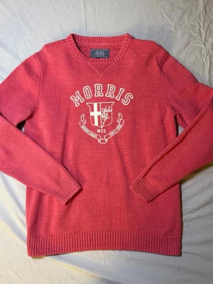 Morris stickad crewneck – Röd – Strl L – Vintage – Mycket bra skick - Säljer en stickad Morris crewneck i röd färg, storlek L, i mycket bra skick. Vintage-känsla med snyggt tryck på framsidan som ger karaktär.  Perfekt för preppy, casual eller clean stil. Funkar både ensam och under jacka.  Mått: Undersida: 46 cm Längd: 70 cm  • Märke: Morris • Typ: Stickad crewneck • Skick: Mycket bra  Morris 2