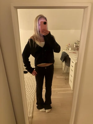 Marinblå kofta från ginatricot - Mysig marinblå kofta från ginatricot med rund halsringning och knappar framtill. Koftan är stickad och har en lite fluffig känsla, perfekt att slänga på sig över ett linne. Långärmad och något croppad modell. Ser bara svart ut i mitt ljus.