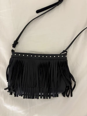 Zara shoulder bag - Turn heads with this chic Zara shoulder bag featuring stylish fringe details and shiny silver studs ✨. Perfect for festivals, nights out, or adding a rock-chic touch to any outfit. Adjustable strap for comfortable wear.  Why you’ll love it: 	•	Only lightly used – looks like new! 	•	Spacious enough for phone, wallet, and essentials 	•	Versatile black color goes with everything 	•	Unique, Instagram-worthy accessory  Grab it before it’s gone – a perfect addition to your wardrobe! 💖