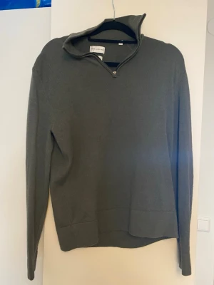 Olivgrön stickad half zip-tröja - Tunn olivgrön half zip från these glory days, knappt använd. Sitter snarare som M än L som det står på den.