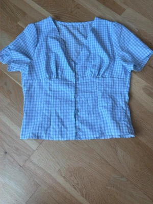 Blå gringham blus - En fin ljusblå blus med knappar fram sldrig använd köpt för 1månad sedan