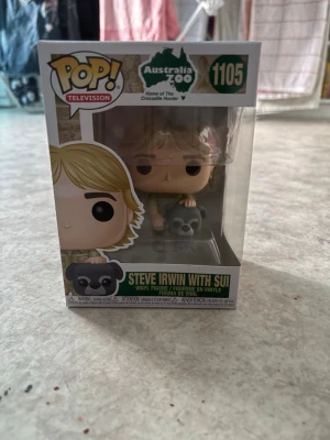 Steve  från Funko Pop - Cool beige väst i safaristil som syns på Steve Irwin-figuren från Funko Pop! Västen har klassisk krage och ärmlös design, perfekt för dig som gillar äventyr och djurtema. Passar dig som vill sticka ut med en ikonisk look inspirerad av Australien. 