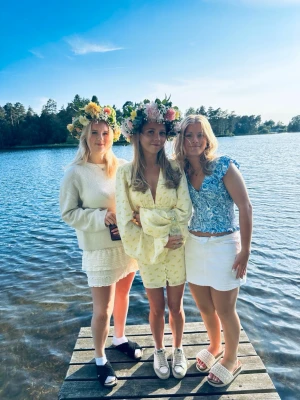 Gul blommig kortklänning från Adoore - Superfin ljusgul kortklänning från Adoore med små blommor, v-ringning och långa puffärmar. Klänningen har knappar framtill och markerad midja som ger en snygg siluett. Perfekt för sommarens alla tillfällen!